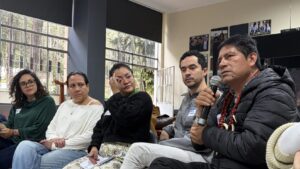 5 workshop participants discussing with one speaking on the microphone