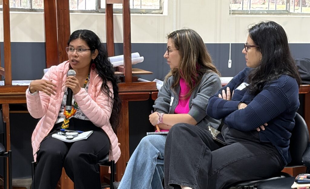 3 workshop participants discussing with one speaking on the microphone