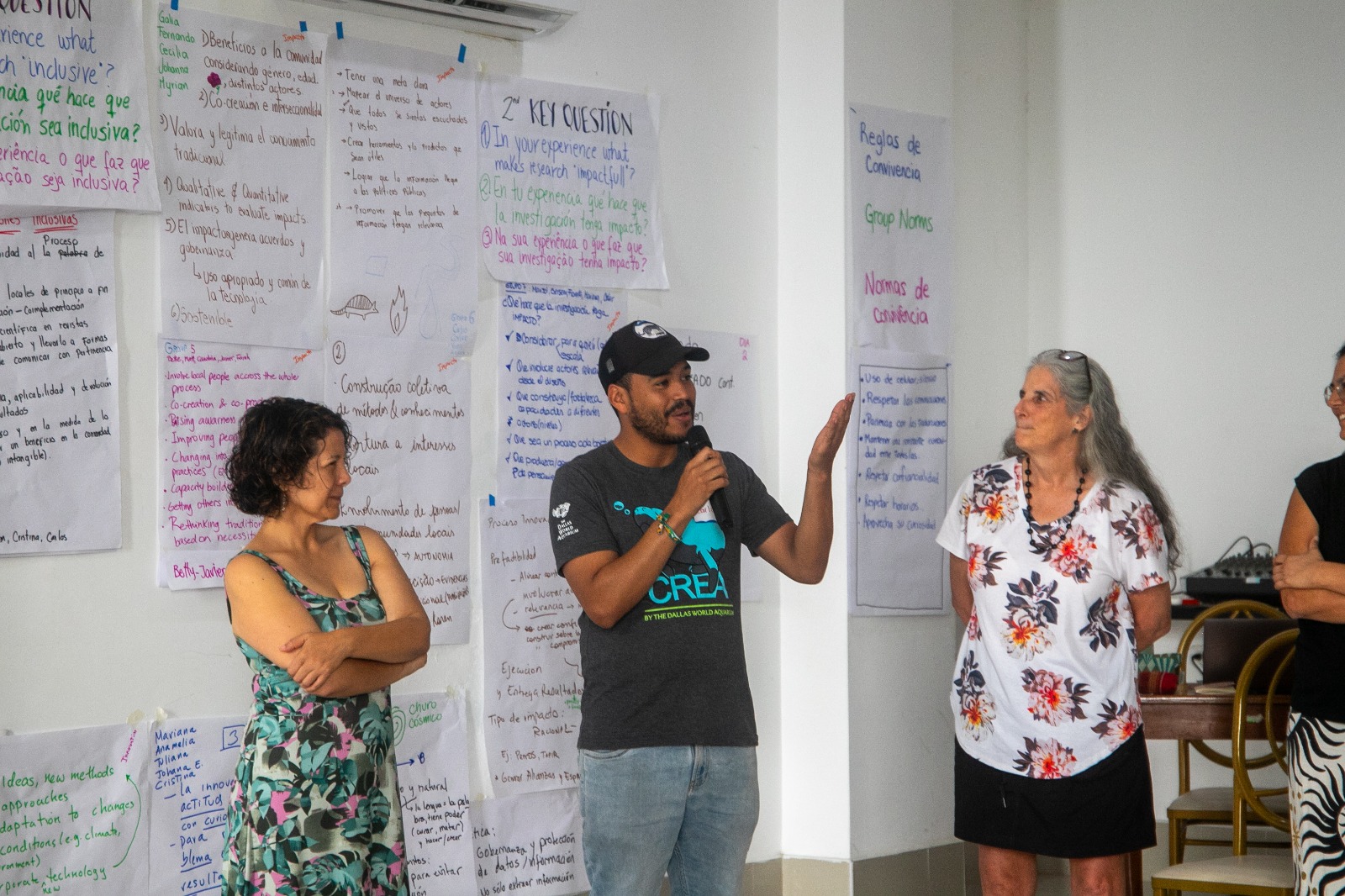 4 workshop participants discussing with one of them talking to the audience